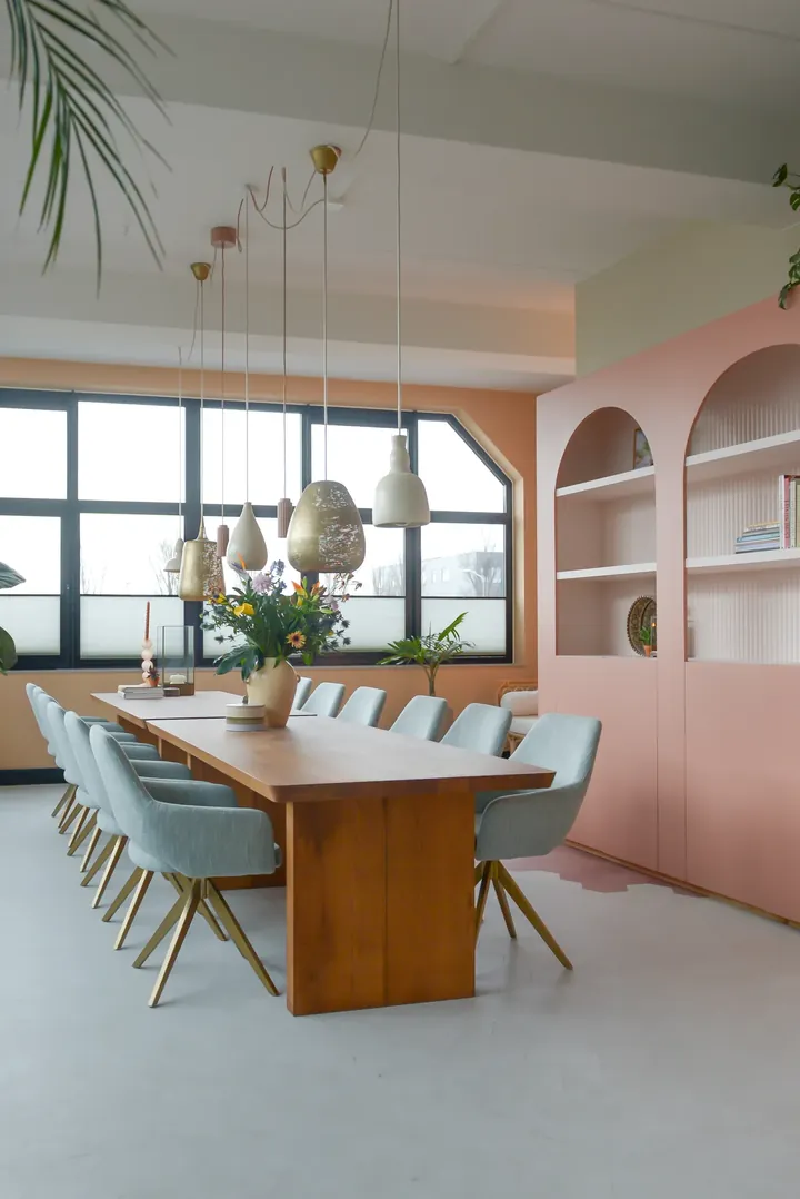 Langer Holztisch mit hellblauen Esszimmerstühlen Yanai von Jesper Home vor rosa Wandregalen