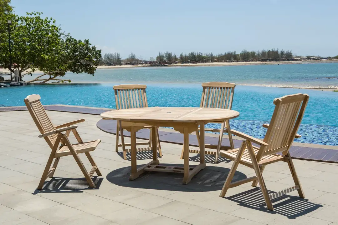 Essgruppe von Möbilia aus Teakholz auf einer Terrasse am Pool